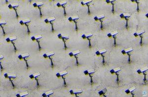 a pattern of CCTV surveillance cameras on a wall, moshed with a blue and yellow jitter effect, all pointing in different directions.