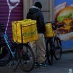 A cyclist working for the food delivery service Glovo waits in a street of Milan.