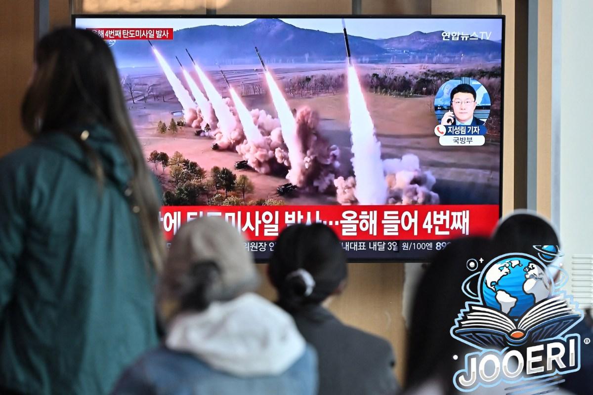 People watch a television screen showing a news broadcast with file footage of a North Korean missile test, at a railway station in Seoul on April 22, 2024. North Korea has fired an unidentified ballistic missile into the sea off South Korea's east coast.