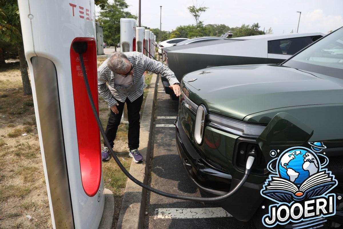 Rivian SUV charging at a Tesla Supercharger.