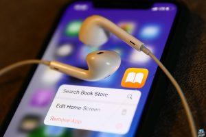Apple Books icon displayed on a phone with headphones