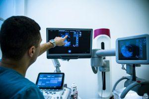 Doctor examining breasts with mammogram