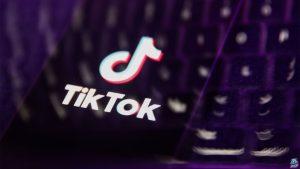 A laptop keyboard and TikTok logo displayed on a phone screen are seen in this multiple exposure illustration.