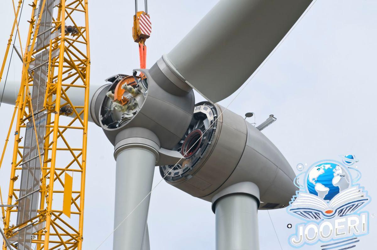 A crane positions the rotor of a wind turbine during construction.
