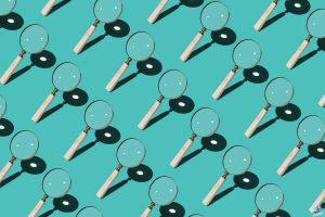Magnifying Glass Focusing Sunlight Into a Point Repetition on Turquoise Colored Background High Angle View.