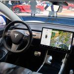 Tesla Model 3 compact full electric car interior with a large touch screen on the dashboard.