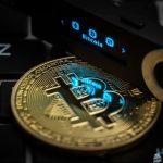 The word Bitcoin can be seen on the display of a Ledger Nano S hardware wallet next to a symbolic "Bitcoin coin". Photo: Silas Stein/dpa (Photo by Silas Stein/picture alliance via Getty Images)