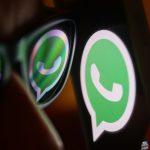 WhatsApp logo reflected on sunglasses and displayed on a phone screen.