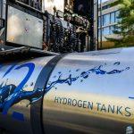 A hydrogen tank sits attached to an idle semi truck.