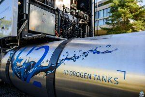 A hydrogen tank sits attached to an idle semi truck.