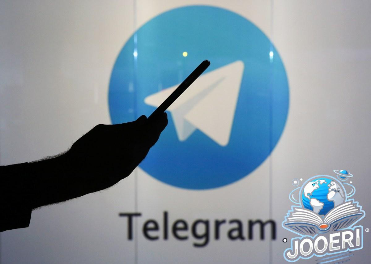 Telegram logo behind silhouette of person checking a mobile device