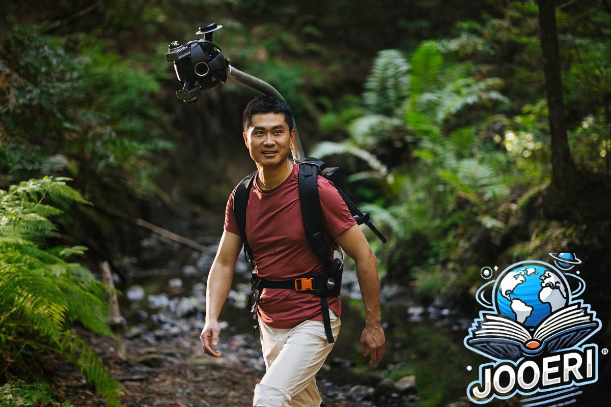 Man hiking in a forest wearing Odyssey camera pack