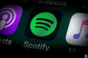The buttons of the music streaming app Spotify, surrounded by Podcasts, Apple Music, Facebook and other apps on the screen of an iPhone.